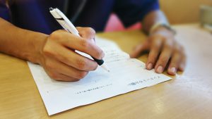 アンケート用紙に記入する男性